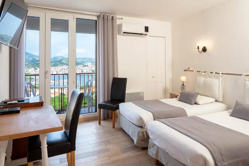 Une chambre lumineuse avec vue sur la mer et la ville.