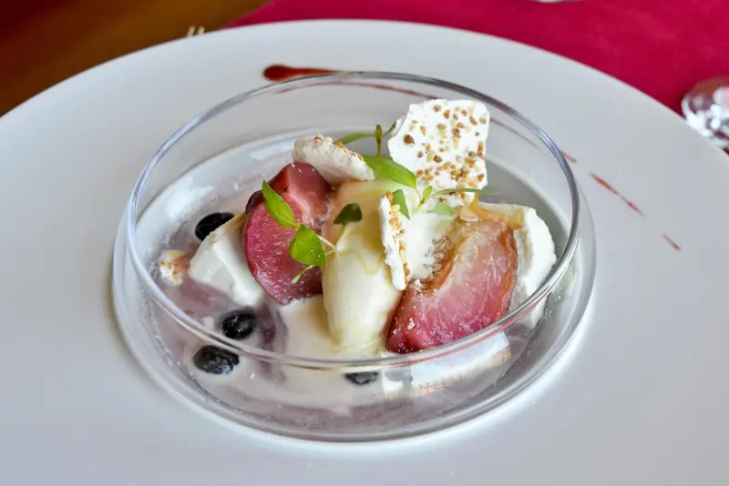 Présentation d'un dessert à base de fruits et de crème.