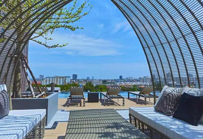 Terrasse avec mobilier de détente et piscine offrant une vue sur la ville.