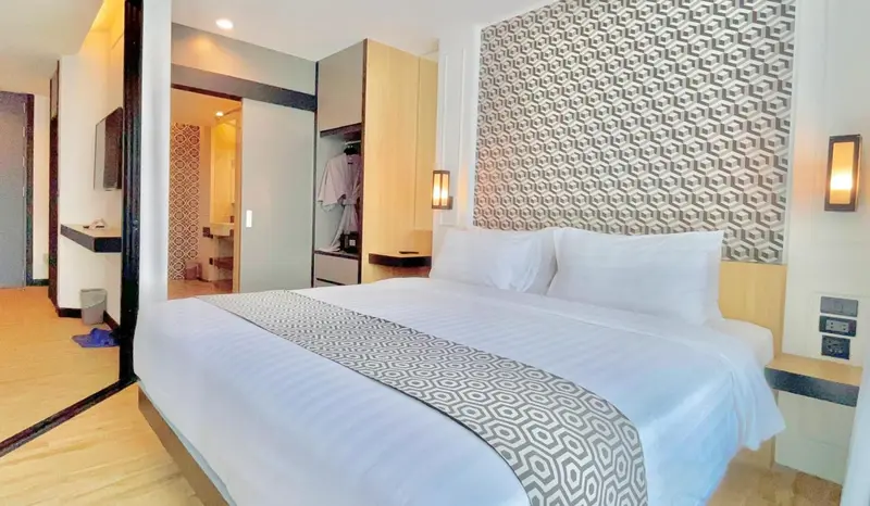 Une chambre lumineuse avec un grand lit et un décor moderne.