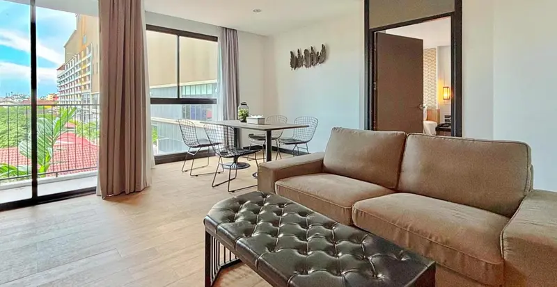 Un salon lumineux s'ouvre sur une terrasse avec table et chaises.