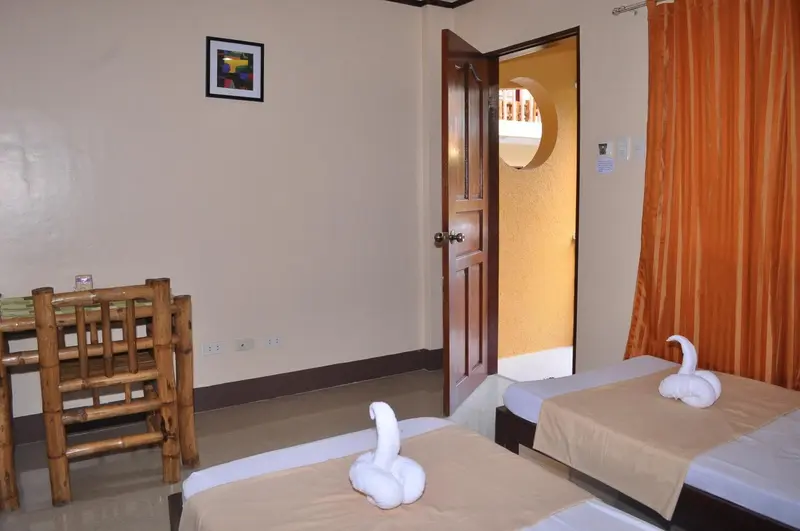 Une chambre avec deux lits simples et une table.