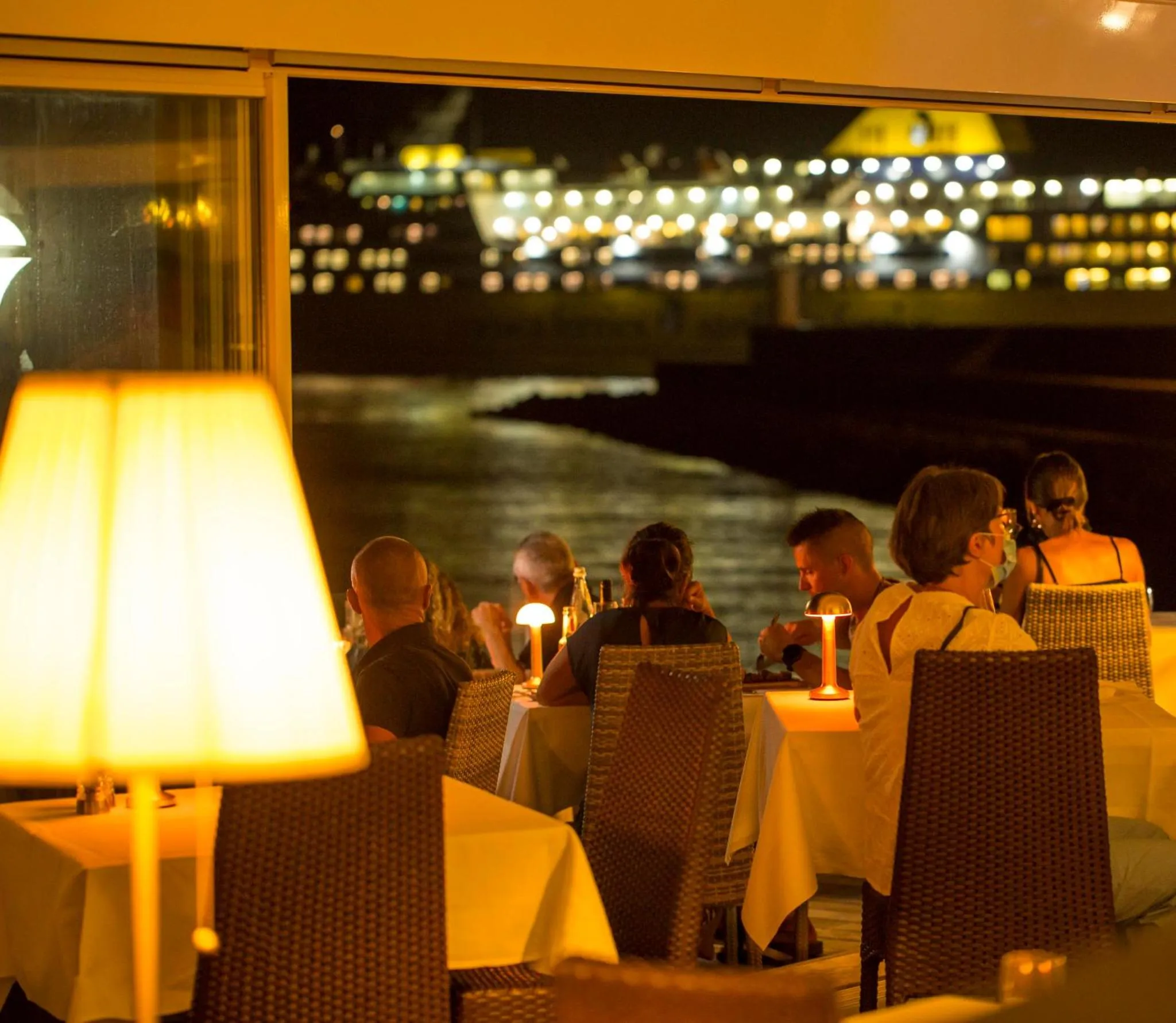 Une salle à manger lumineuse avec vue sur une ville illuminée la nuit.