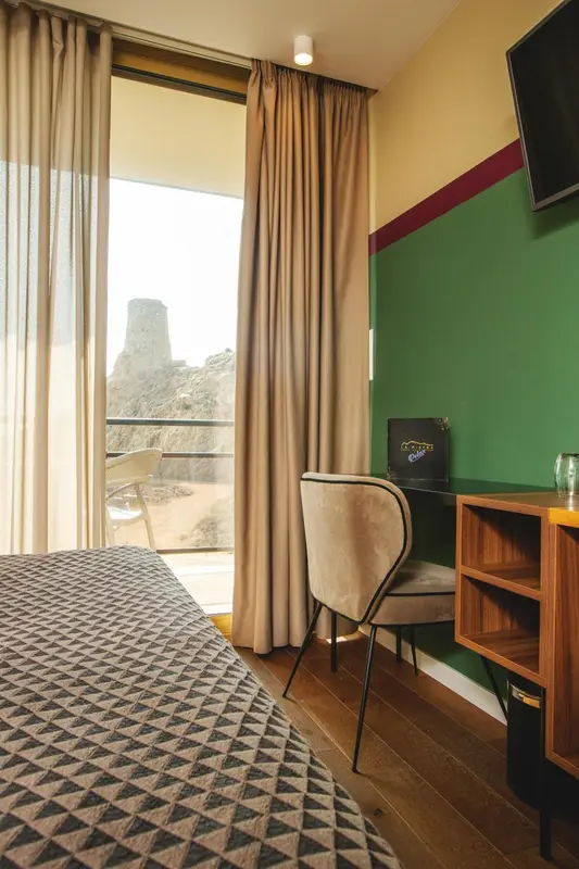Une chambre avec un grand lit et une vue sur un paysage rocheux.