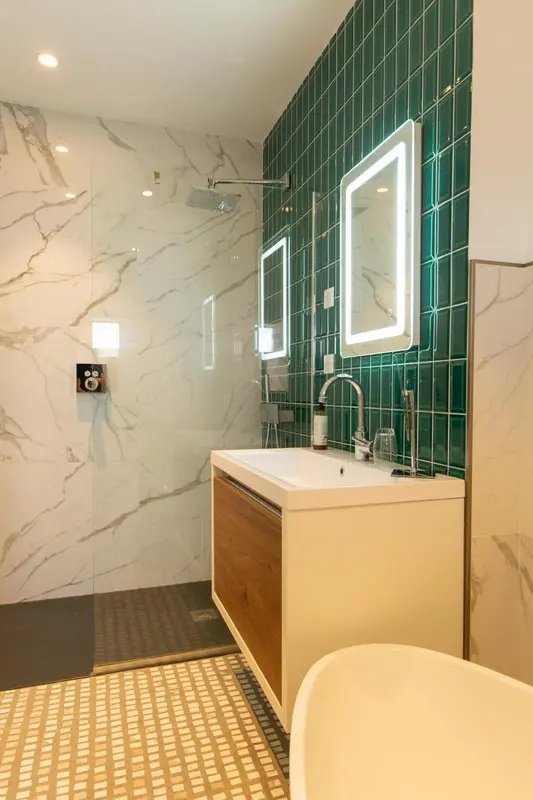 Une salle de bain moderne avec une douche à l'italienne et un lavabo lumineux.
