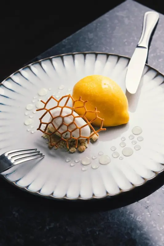 Assiette raffinée avec une préparation à base de fruit et d'une structure en sucre.