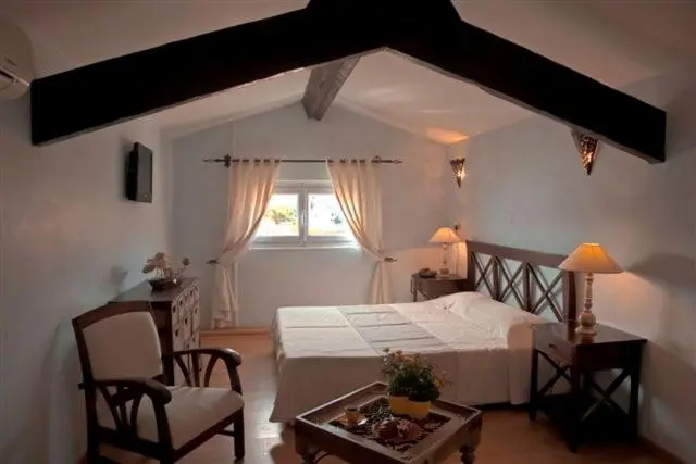 Une chambre lumineuse avec un lit blanc et des meubles en bois.