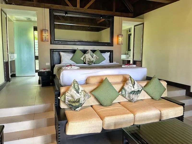 Une chambre spacieuse avec un grand lit et un coin salon.