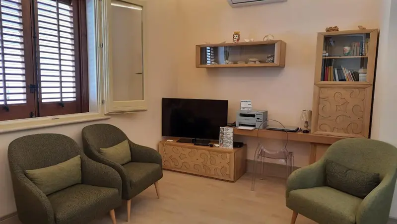 Espace de détente avec deux fauteuils et une télévision.