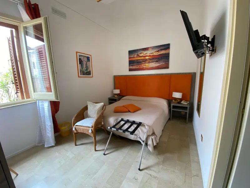 Une chambre lumineuse avec un grand lit et un tableau décoratif.