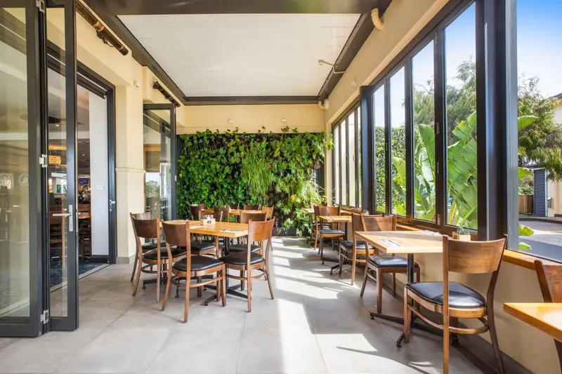 Une salle à manger lumineuse avec des tables et des chaises en bois.