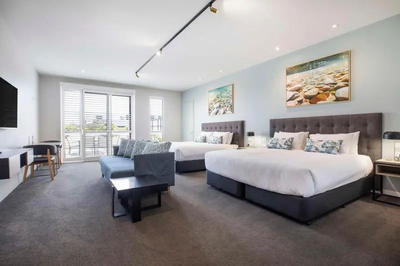 Une chambre spacieuse avec deux lits et un coin salon.
