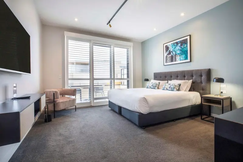 Une chambre moderne avec un grand lit et un accès à une terrasse.