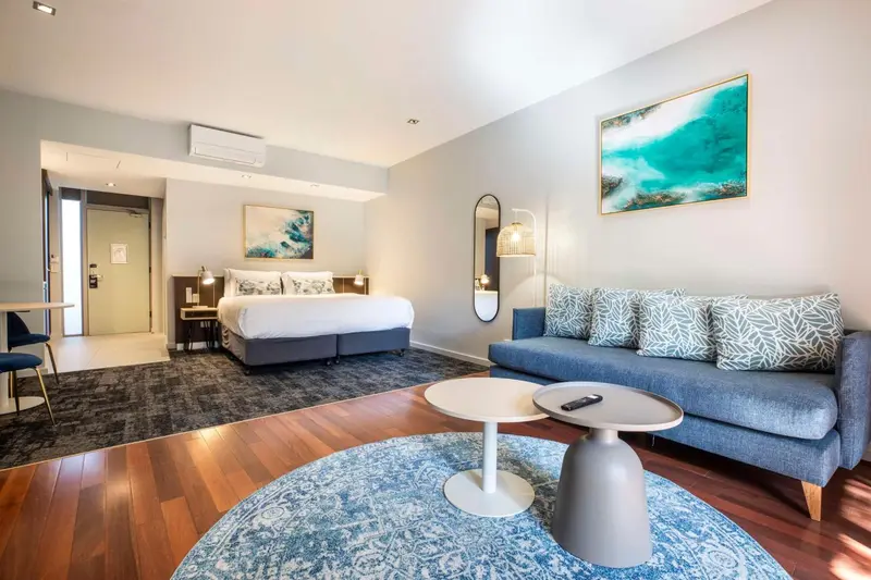 Une chambre lumineuse avec un canapé et un grand lit.