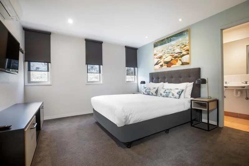 Une chambre lumineuse avec un grand lit et une décoration sobre.