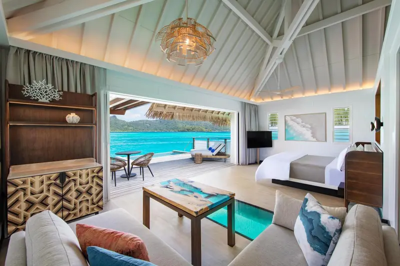 Une chambre lumineuse s'ouvre sur une terrasse avec vue sur l'océan.
