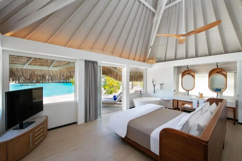 Une chambre lumineuse avec un lit king-size et un accès direct à une terrasse avec vue sur l'océan.