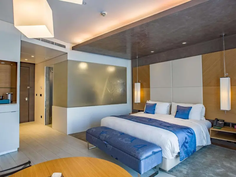 Chambre moderne avec un grand lit et une décoration sobre.