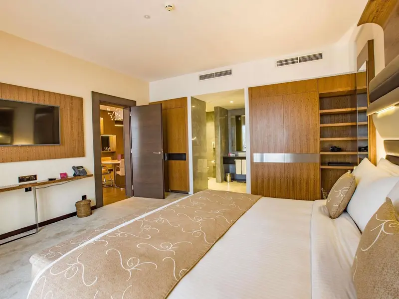 Chambre lumineuse avec un grand lit et un espace détente.
