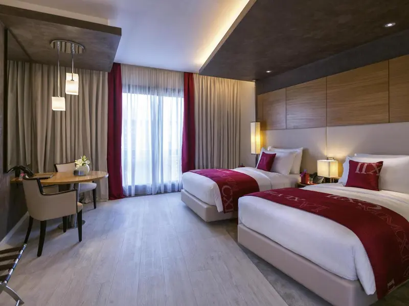Chambre avec deux lits simples et une petite table.