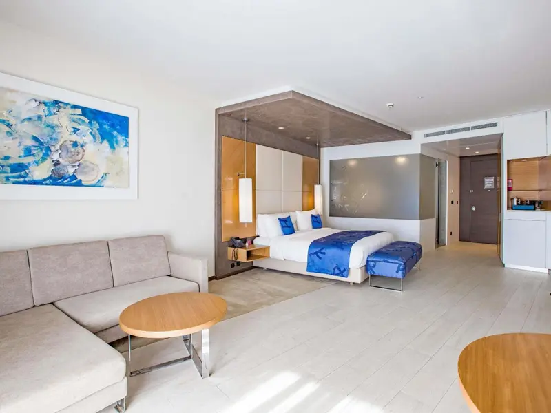 Espace de vie lumineux avec canapé, lit et décoration moderne.