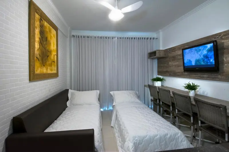Une chambre avec deux lits simples et un espace repas.