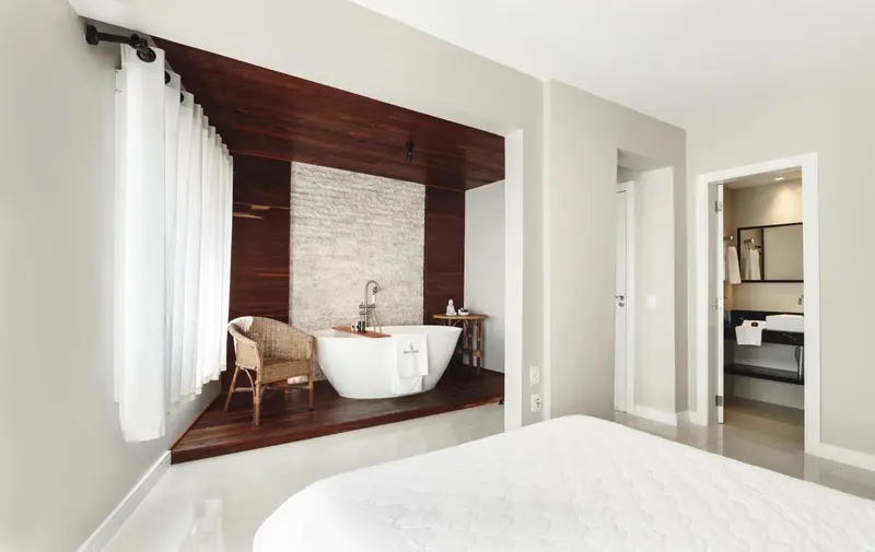 Une baignoire sur pieds se trouve dans une salle de bain lumineuse.