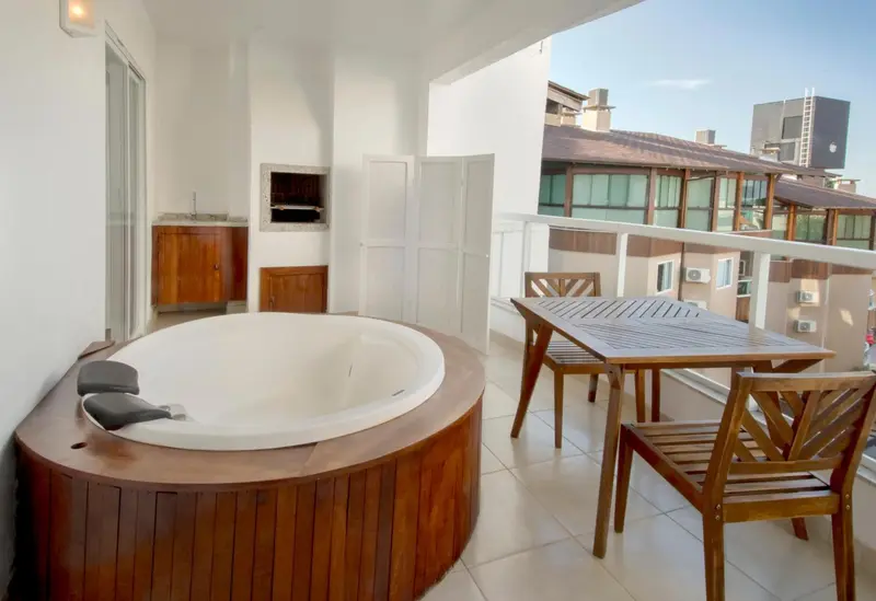 Terrasse avec jacuzzi et mobilier de jardin en bois.