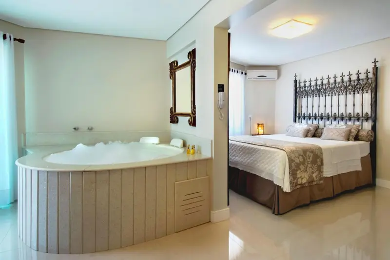 Une chambre spacieuse avec un jacuzzi et un grand lit.