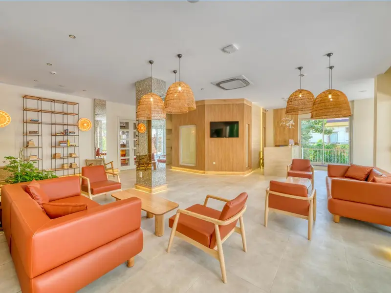 Espace de détente intérieur avec canapés et luminaires suspendus.