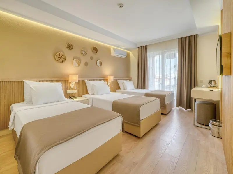 Chambre lumineuse avec deux lits simples et une décoration murale.