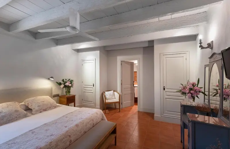 Une chambre lumineuse avec un lit à baldaquin et une décoration florale.