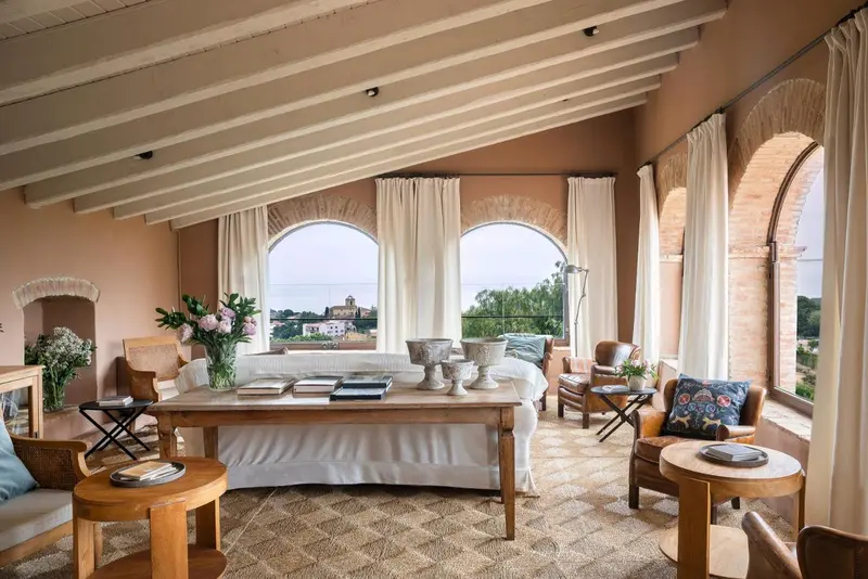 Espace de séjour lumineux avec mobilier en bois et vue sur un paysage urbain.