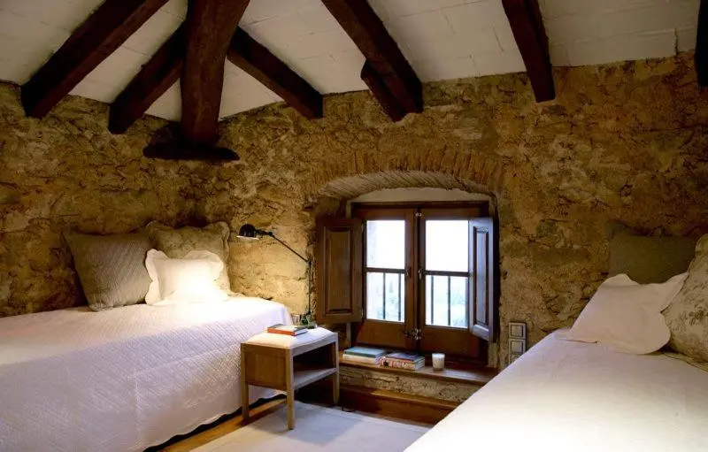 Une chambre rustique avec des murs en pierre et des poutres apparentes.