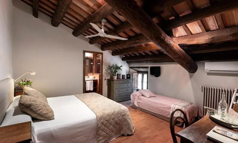 Une chambre lumineuse avec un plafond en bois apparent et deux lits.