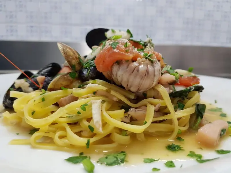 Assiette de pâtes aux fruits de mer et herbes fraîches.