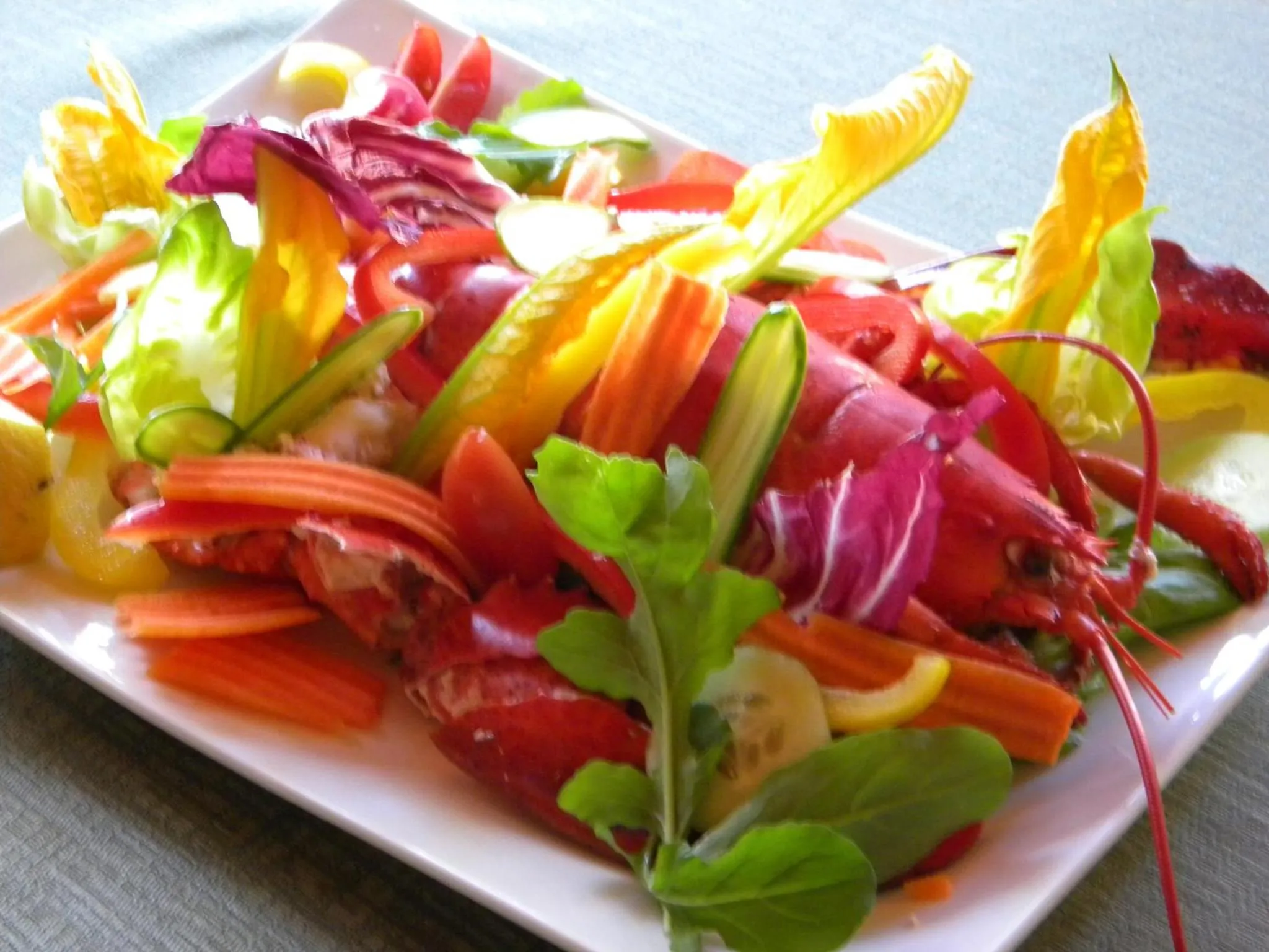 Une assiette colorée de salade fraîche est présentée sur une table.