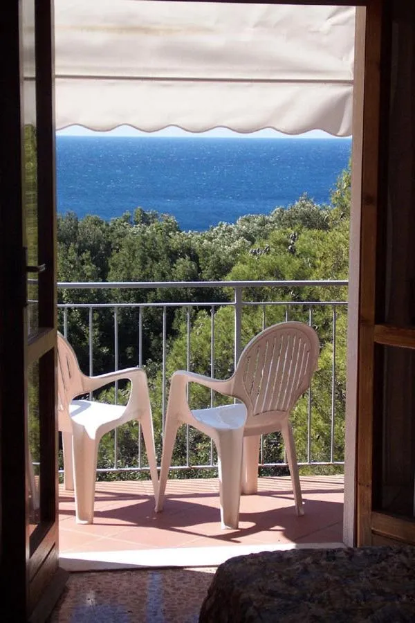 Vue sur la mer depuis une terrasse avec des chaises en plastique.