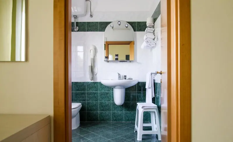 Une salle de bain lumineuse avec douche, lavabo et toilettes.