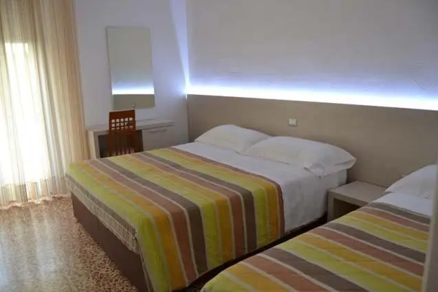 Une chambre avec deux lits simples et une décoration sobre.