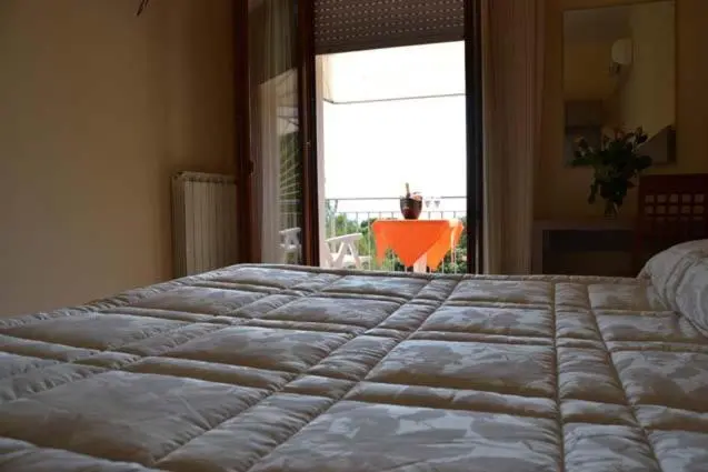 Une chambre avec un lit fait donnant sur une terrasse.