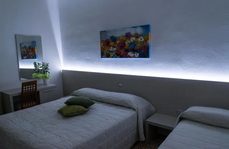 Une chambre lumineuse avec deux lits simples et une décoration murale.