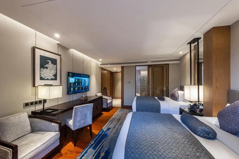 Chambre moderne avec deux lits et un coin salon.