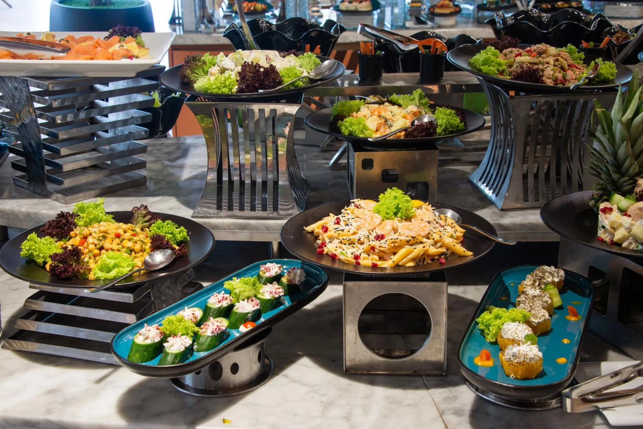 Un buffet propose une variété de salades colorées et de plats préparés.