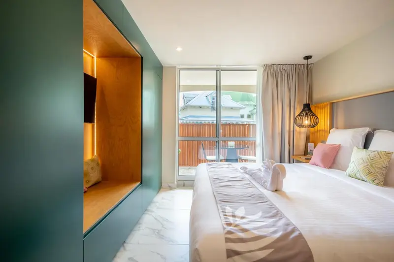 Une chambre lumineuse avec un grand lit et un accès à une terrasse.
