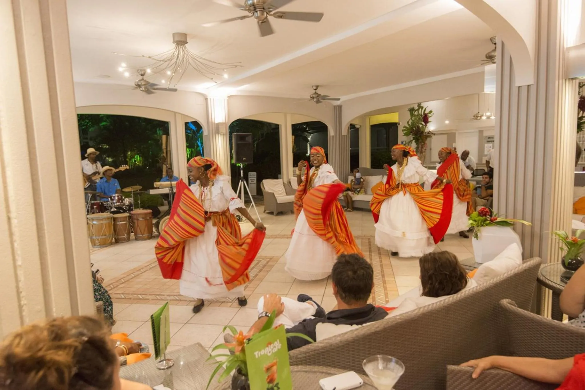 Spectacle de danseurs en costumes colorés sur une terrasse éclairée.