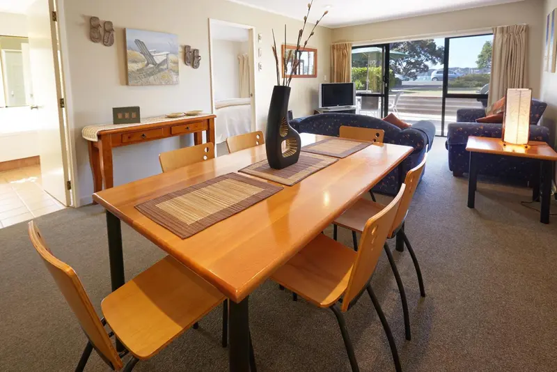 Une salle à manger lumineuse avec une table en bois et des chaises.