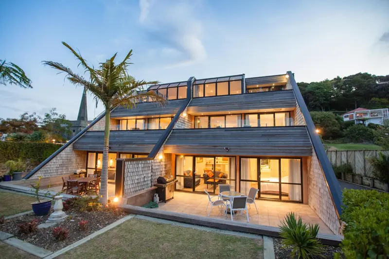 Bâtiment moderne avec de grandes fenêtres et une terrasse éclairée.