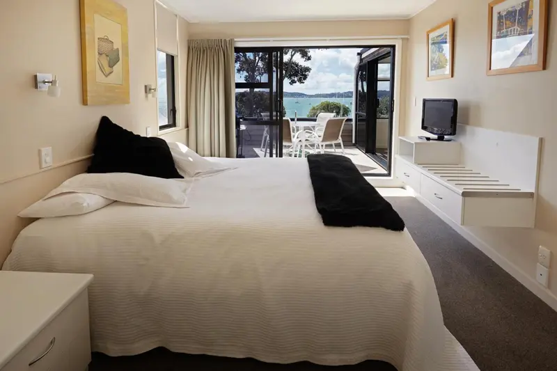 Une chambre lumineuse s'ouvre sur une terrasse avec vue sur la mer.