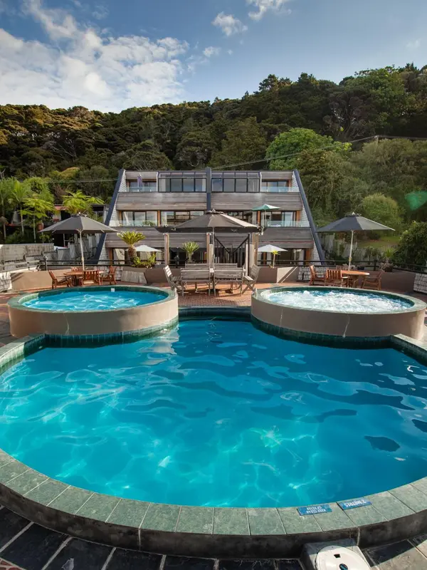 Vue d'un complexe hôtelier avec piscine et végétation luxuriante.